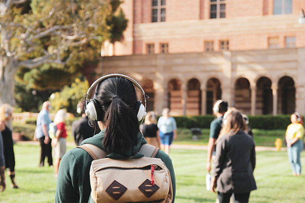 Woman with headphones in on UCLA Campus