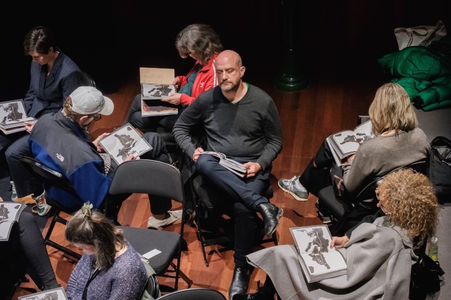 Participants sitting in chairs at a performance of 'Borderline Visible'