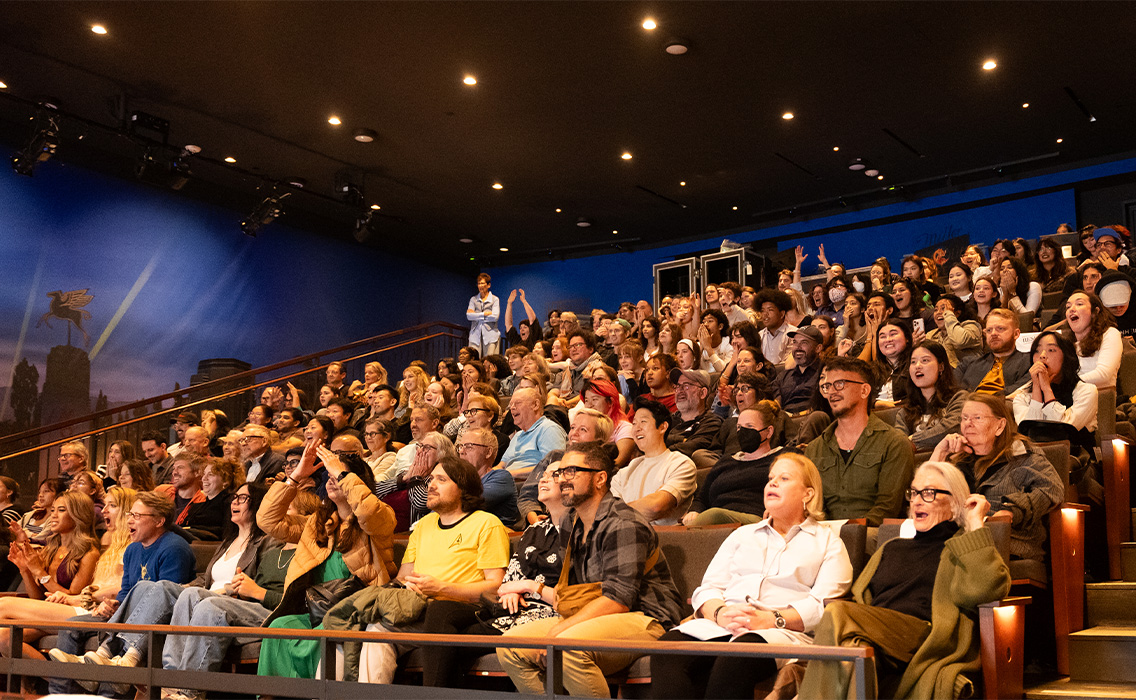 Photo of audience sitting in seats at The Nimoy, reacting with suprise at something on stage/off camera