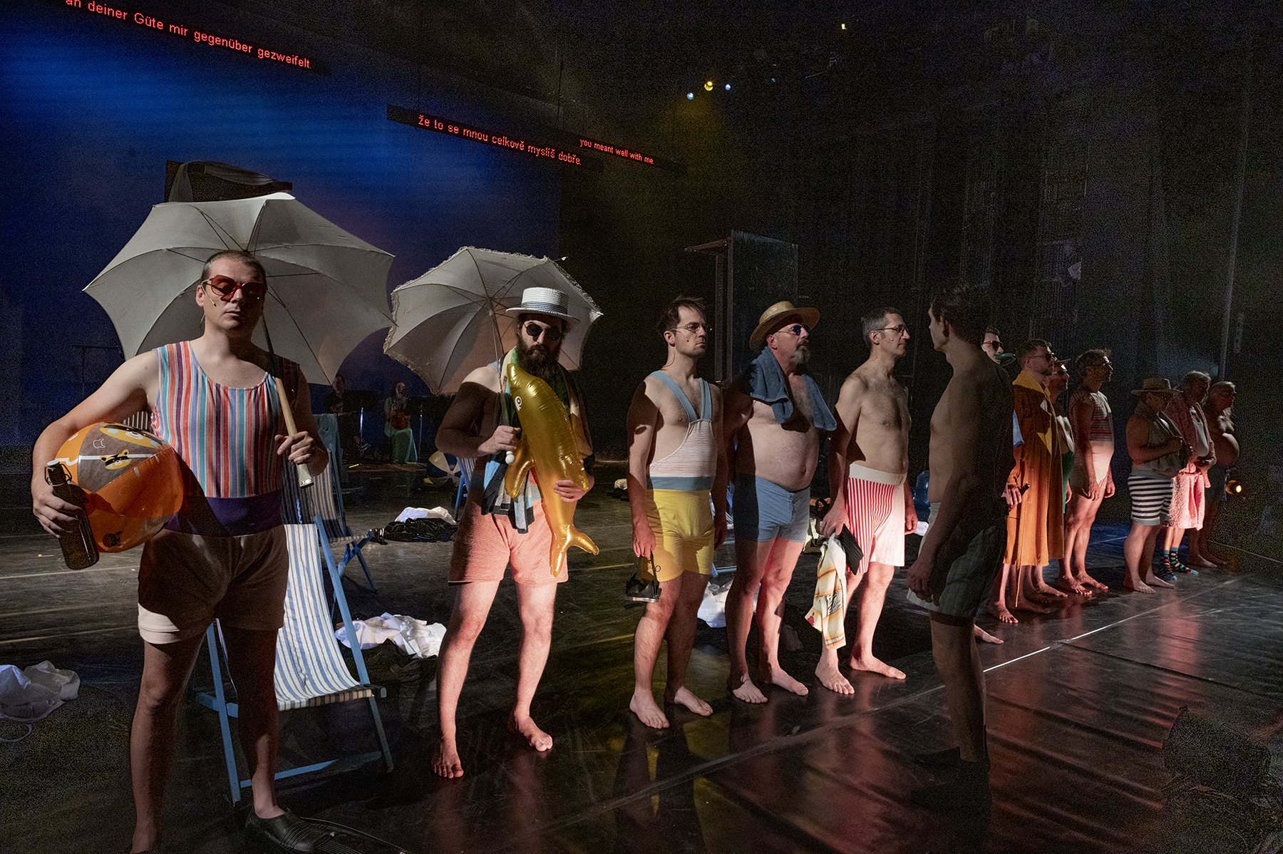 Actors with beach clothes and umbrellas