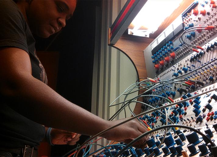 Award-winning composer and sound artist Yvette Janine Jackson working on a lighted sound board