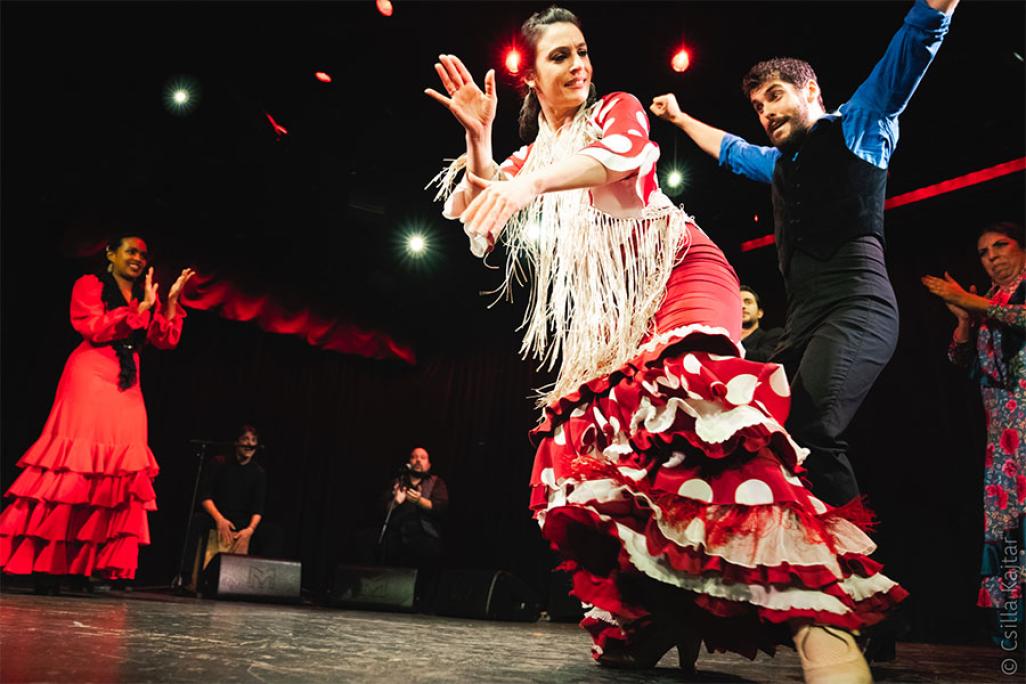 Close up of two dancers with people clapping in the background