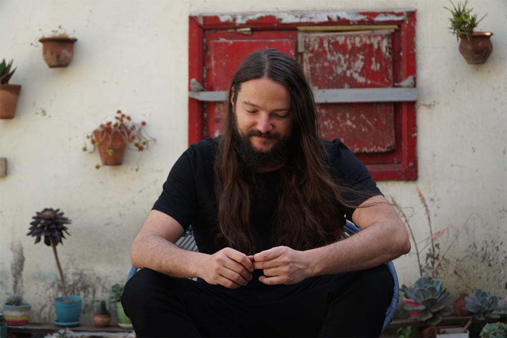 Nano Stern sits in front of a red door