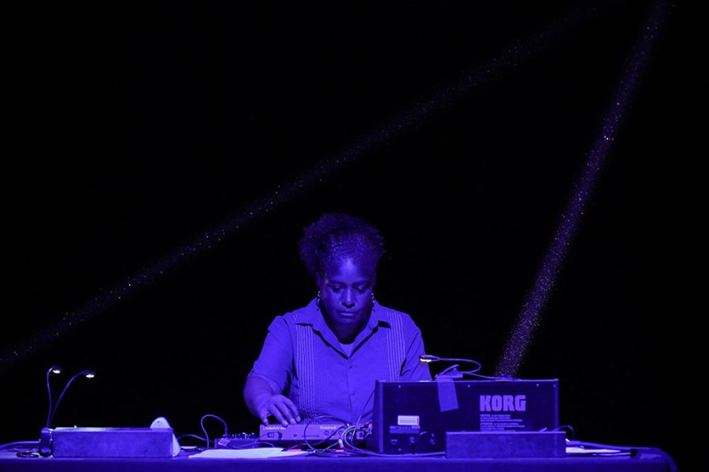 Yvette Janine Jackson performing with electronic equipment with blue lighting