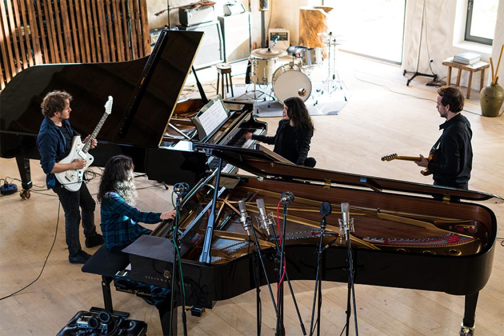 Dream House Quartet rehearses around a piano in 900x600