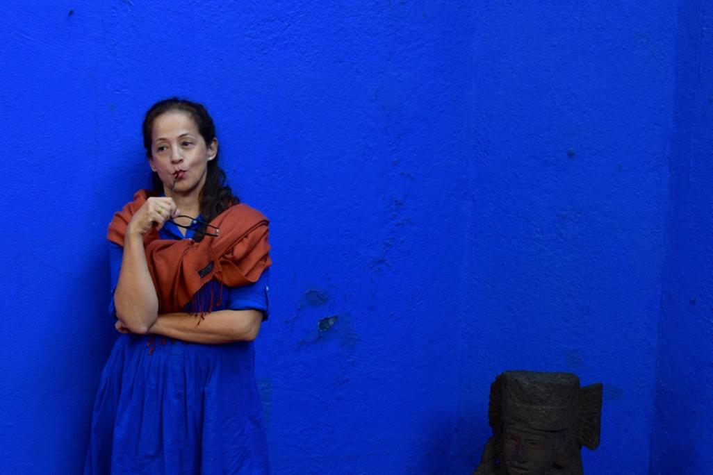 Perla Batalla stands against a blue wall