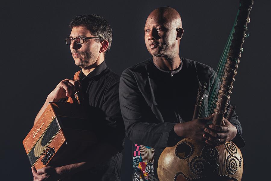 Ablaye Cissoko & Cyrille Brotto stand in front of a black background