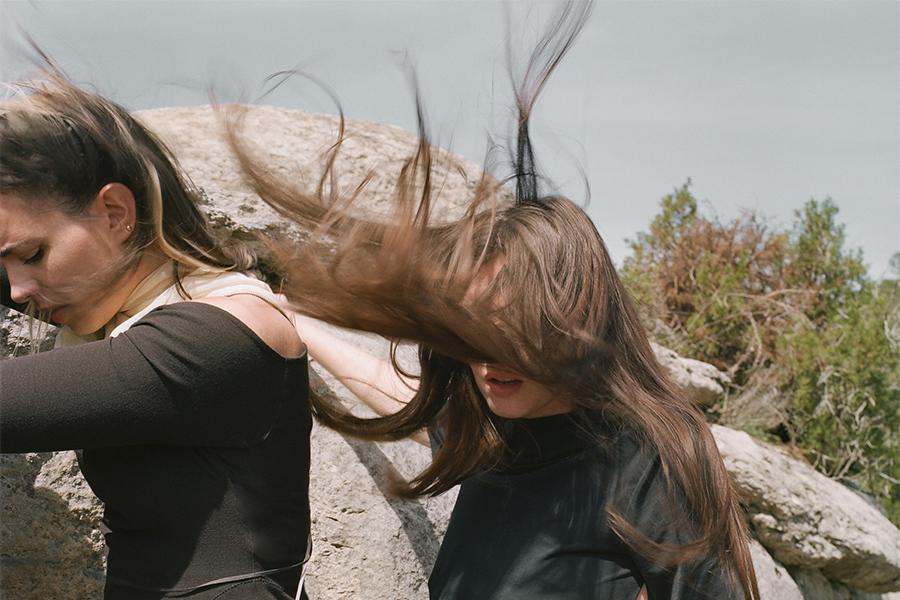 Image of members of Tarta Relena standing outside with wind blowing against their hair