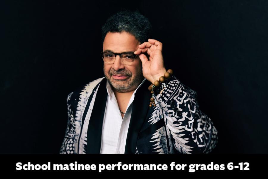 portrait headshot image of Arturo O'Farrill adjusting his glasses
