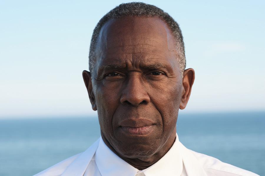 Headshot of Charles Gaines posed in front of an ocean background