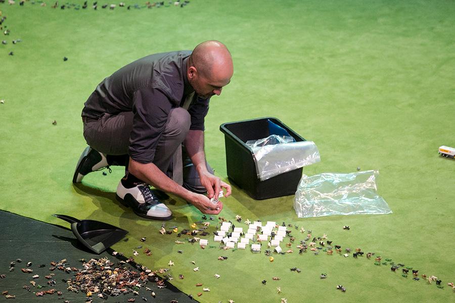 participant on stage setting up 200 miniatures animals for the performance