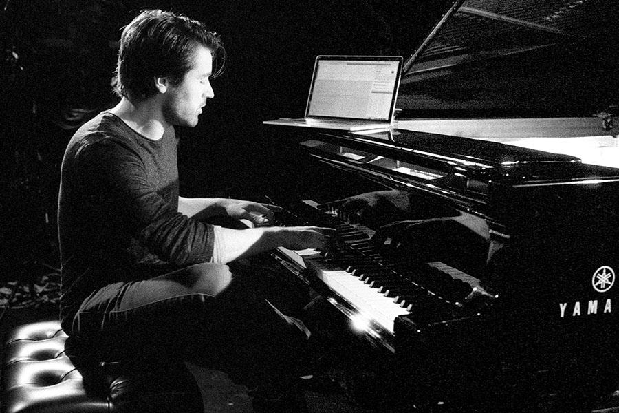Black and white photo of Dan Tepfer at a piano