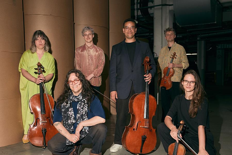 group members of inti figgis-vizueta posing with instruments in warehouse
