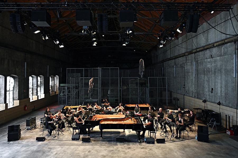 performers from Los Angeles Based band Wild Up around two pianos in a warehouse performing