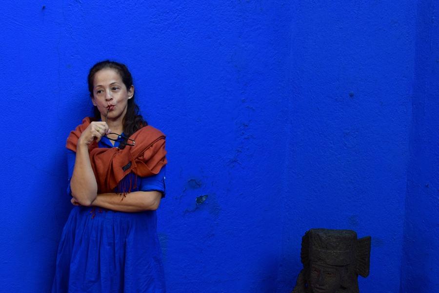 Perla Batalla stands against a blue wall