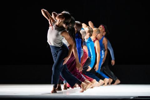 Dancers in a row holding a shape