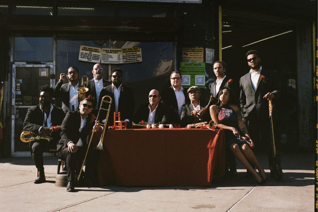 ORQUESTA AKONAN POSES OUTDOORS AROUND A TABLE