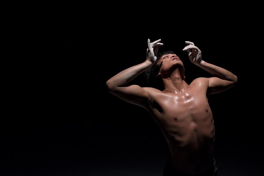 Rianto performs on stage in front of a black background