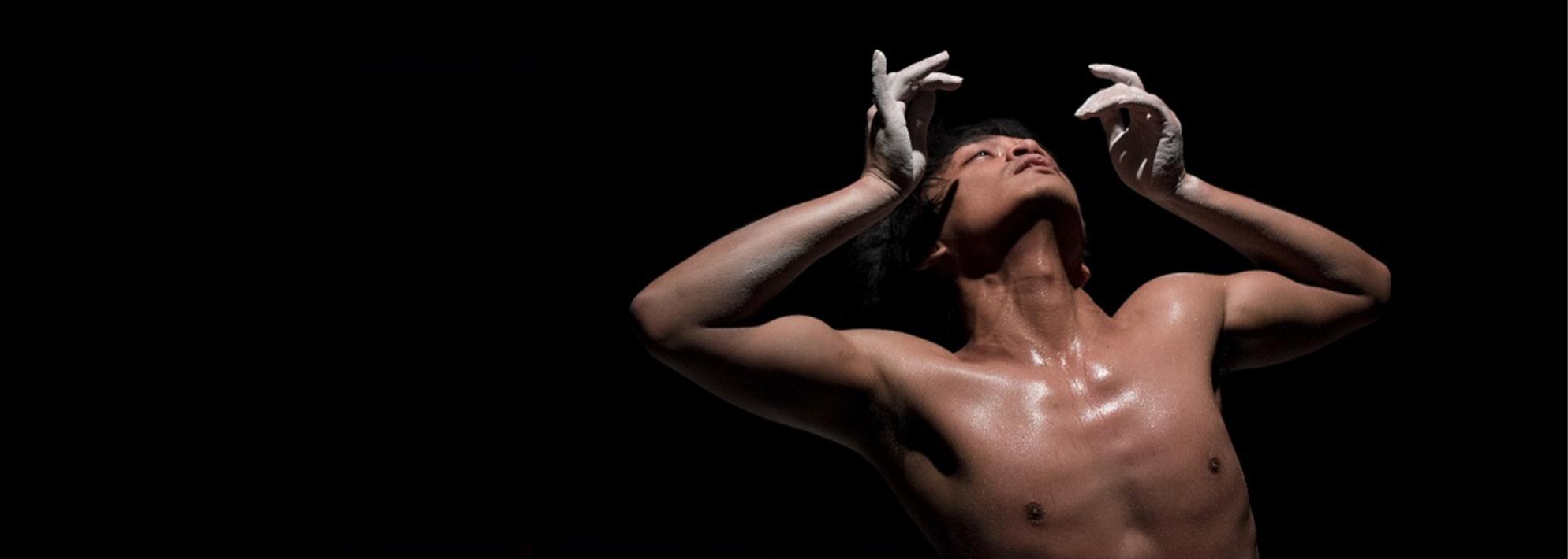 Rianto performs on stage in front of a black background