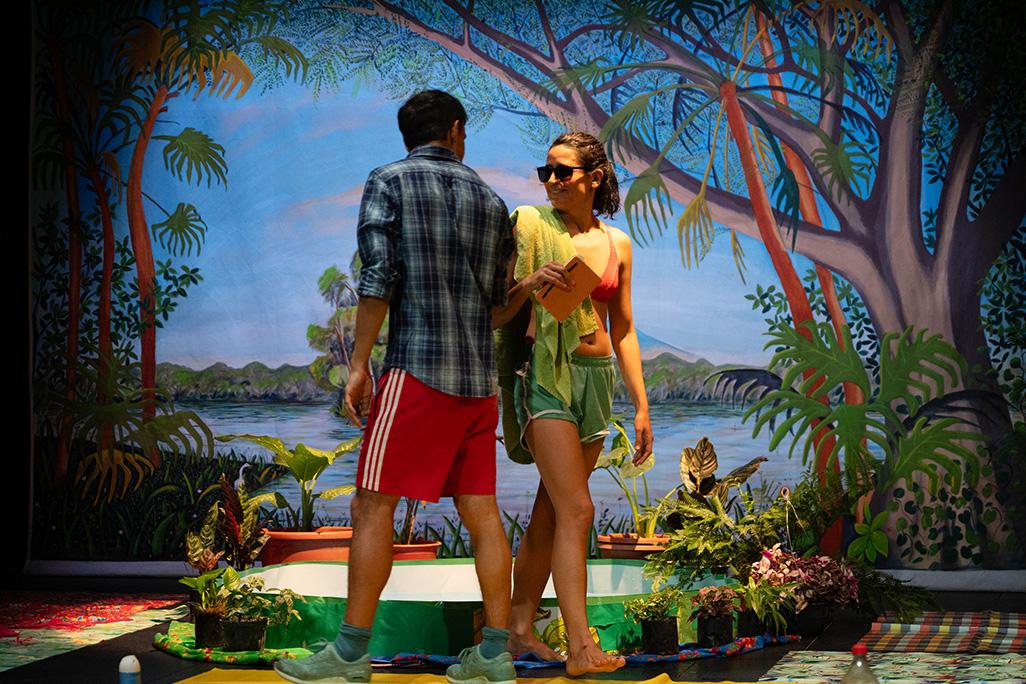 Performers from 'Centroamérica' perform on stage in front of backdrop featuring mountains and trees