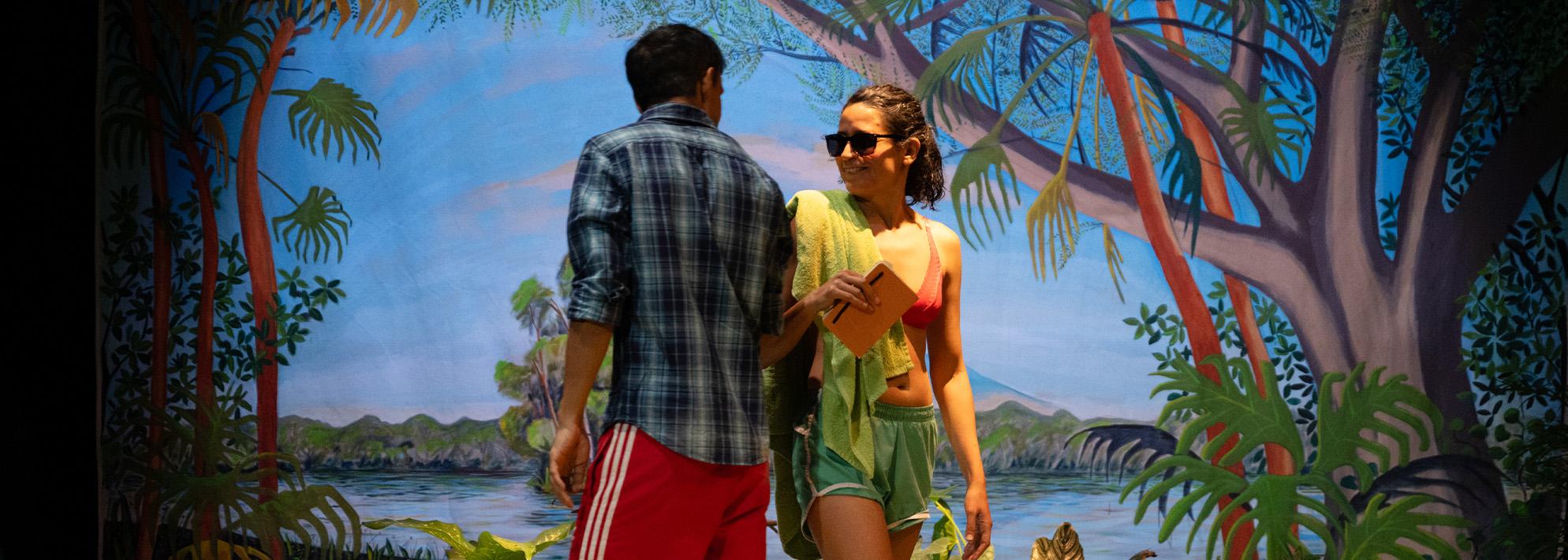 Performers from 'Centroamérica' perform on stage in front of backdrop featuring mountains and trees