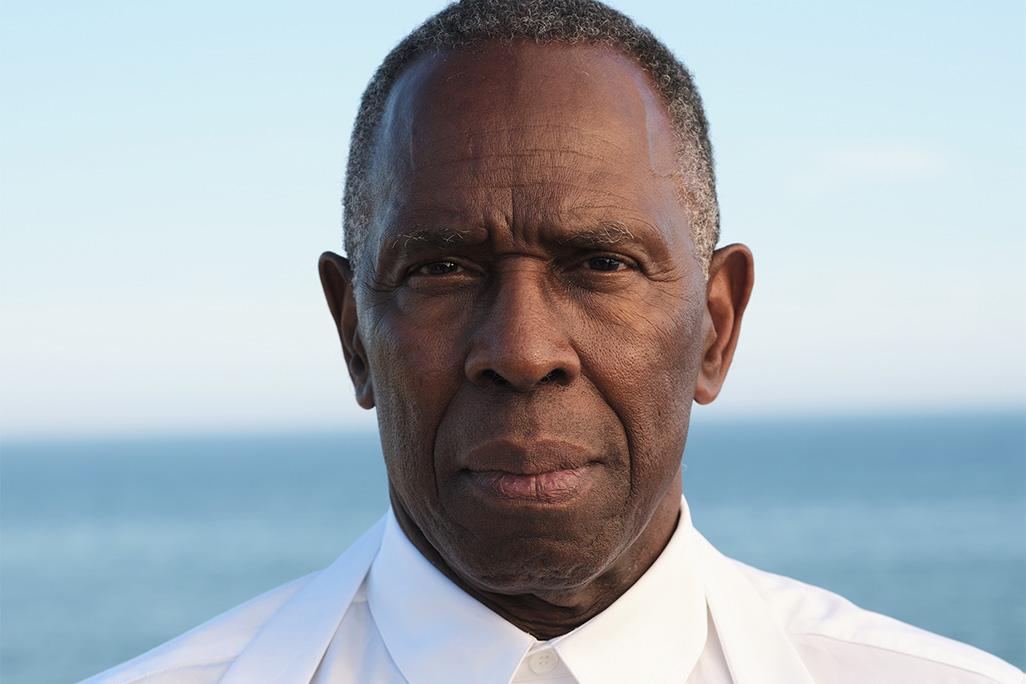 Headshot of Charles Gaines posing in front of an ocean backdrop