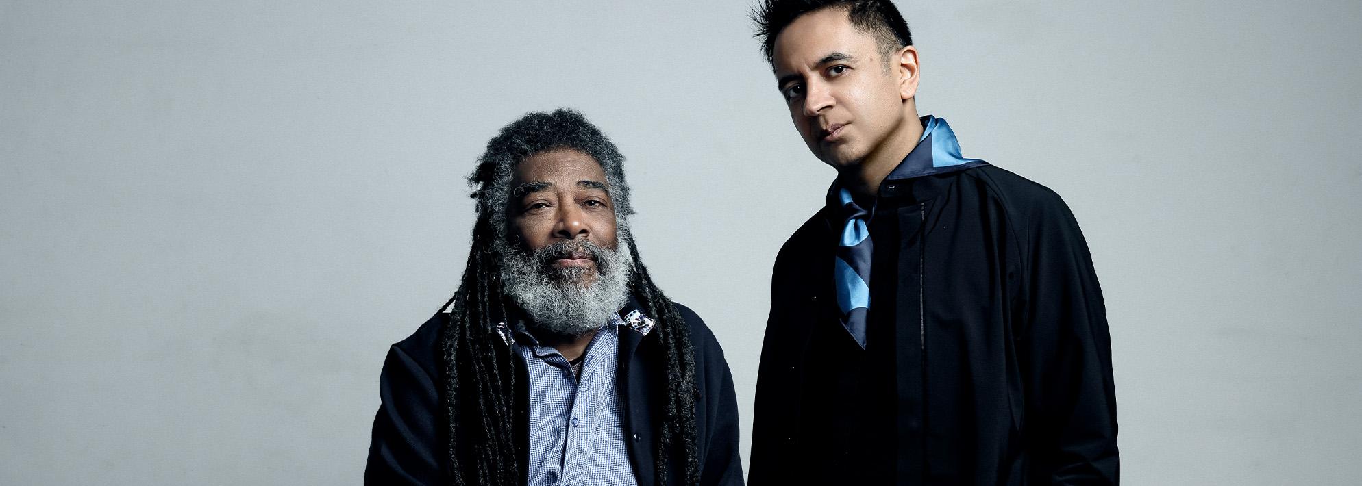 Wadada Leo Smith and Vijay Iyer pose in front of grey backdrop