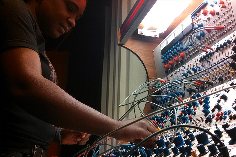 Award-winning composer and sound artist Yvette Janine Jackson working on a lighted sound board